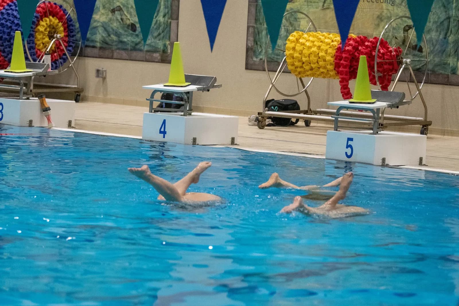 Masters swimmers holding a back layout position across the lane.